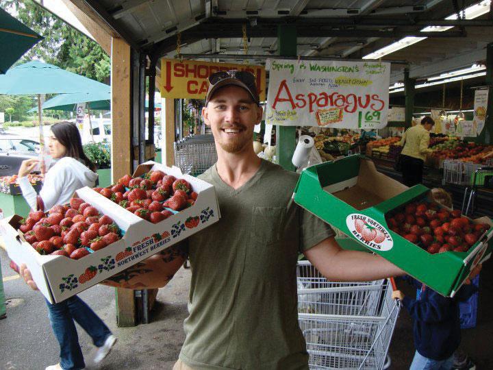 Happy guy with box of fresh strawberries