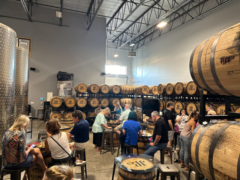 Bourbon Whiskey fans surrounded by Whiskey Barrells at J.P. Trodden Distillery