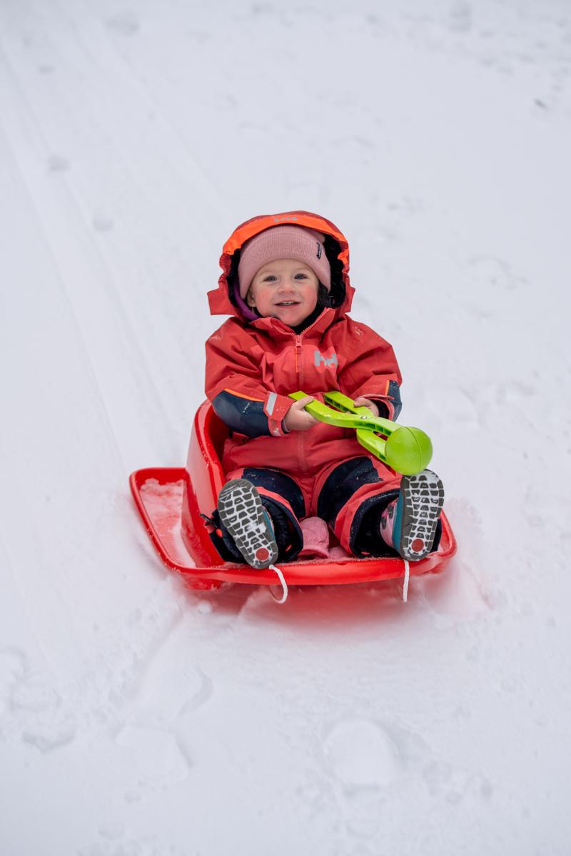 Girl sledding in the winter snow at Stevens Pass