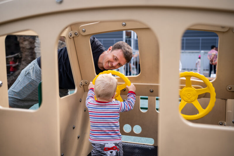 Little boy and his dad learn how to drive a ferry boat at Imagine Children Musem