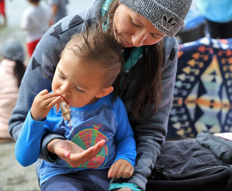 Maria Rios watches her young son devour his first jumbo shrimp