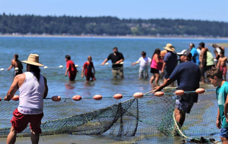Neil Hamilton carrying a salmon from the net